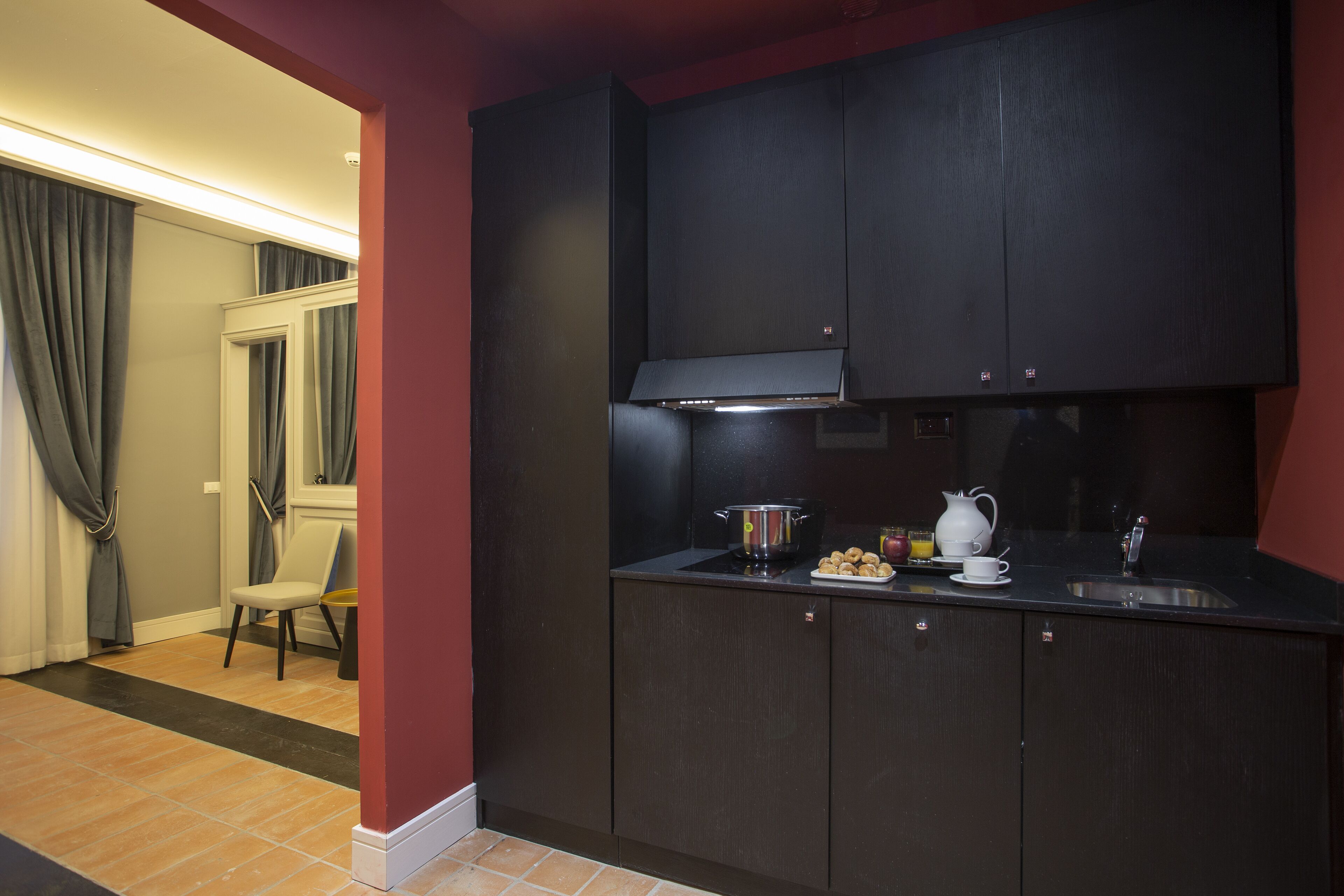 A compact kitchen with dark cabinetry, a stainless steel sink, and a small countertop.