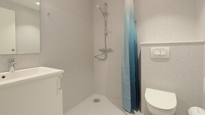 A bathroom with a shower, toilet, sink, and mirror. - Bankbox Hostel Aabybro (Aabybro)