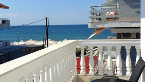 A balcony with a view of the sea, white balustrades, and a table with chairs. - Eantos Studios and Suites (Thermaikos)