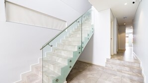 Eine moderne Treppe mit Glastrennstäben und beige marmornen Stufen.