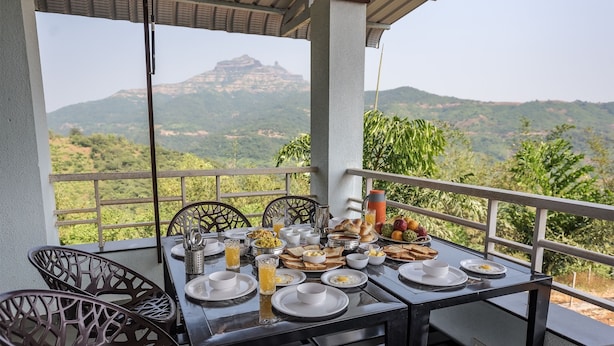 Une table dressée avec des aliments pour le petit-déjeuner et une vue imprenable sur les montagnes.