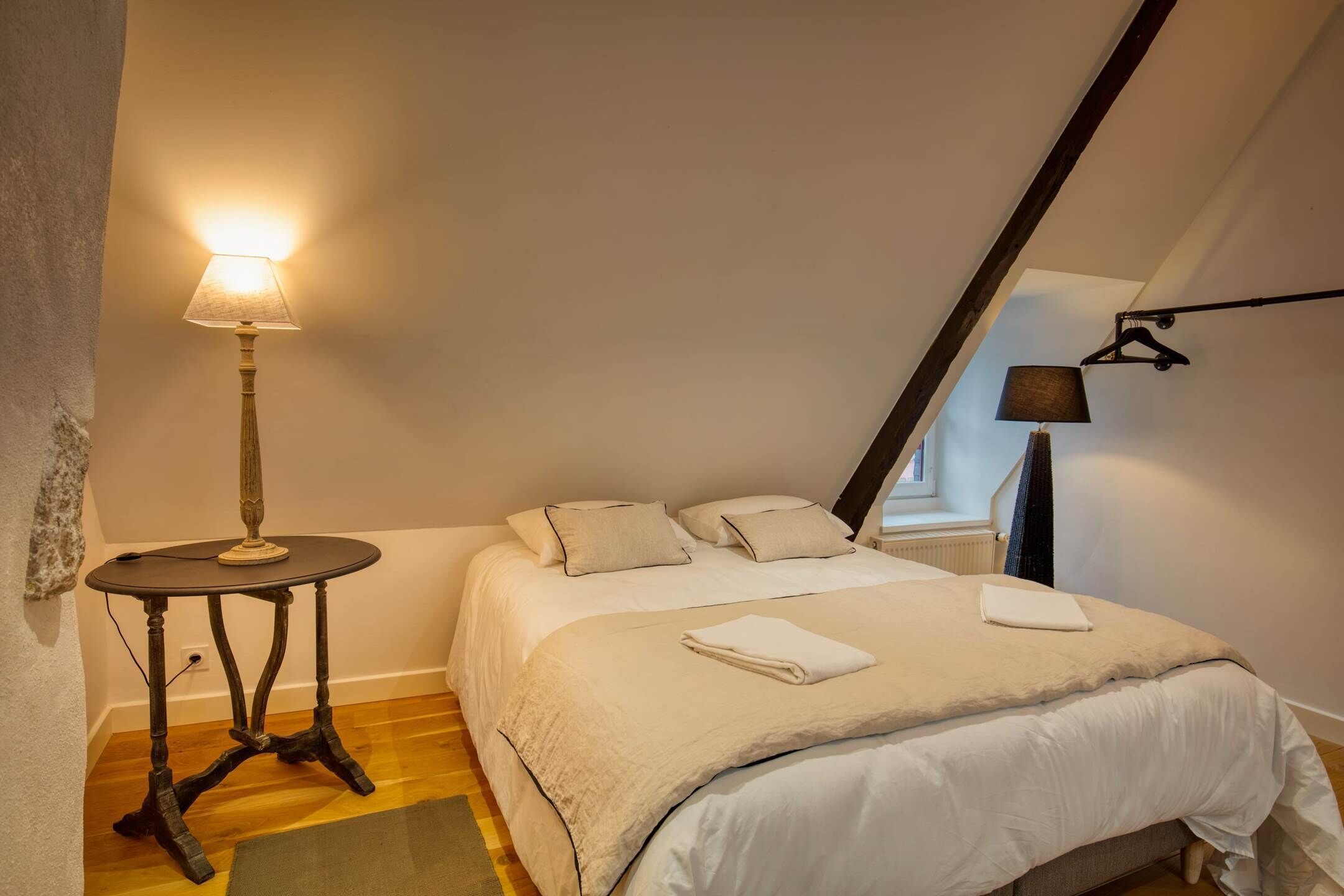 Une chambre à coucher avec un lit, une table de chevet avec une lampe et une lampe suspendue.