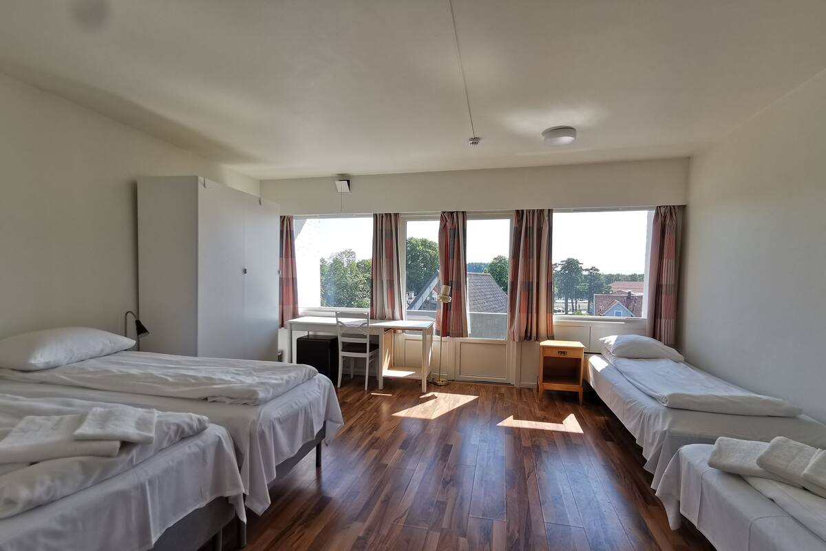 A room with two beds, a desk, and a chair.