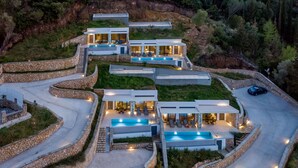 A modern, multi-story house with a swimming pool, stone retaining walls, and a winding driveway. - Modern Villa Omega with Private Pool (LEFKADA)