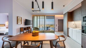 A modern hotel room with a dining area, a TV, a sofa, and a kitchen. - Modern Villa Omega with Private Pool (LEFKADA)