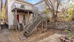 A two-story house with a wooden staircase leading to a front door. - Columbus Park Upper Apt Minutes from Downtown KC (Kansas City)