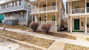 A row of two-story residential buildings with front porches and a visible mailbox.