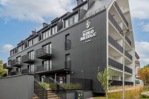Un immeuble d’appartements moderne doté de balcons, d’un escalier et d’une enseigne indiquant qu’il appartient à la société Nickel.