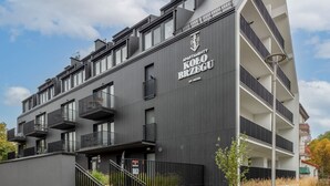 Un moderno edificio residenziale con diversi balconi, una scala e un cartello che indica che si tratta di una proprietà Nickel.