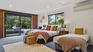 A modern bedroom with two beds, a large window, and a view of greenery. - Lumeah Retreat Adventure Bay, Bruny Island (Adventure Bay)