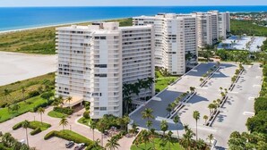Un grand hôtel à plusieurs étages, doté d’un parking et offrant une vue sur la plage et l’océan.