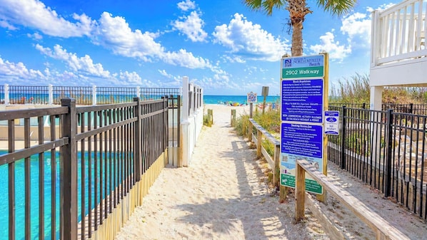 A pathway leading to a beach with a sign indicating Myrtle Beach North Beach and 2902 Walkway.
