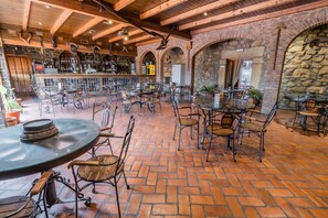 A rustic bar area with stone walls, wooden beams, and metal chairs. - HOTEL RURAL EL LABRIEGO BY VIVERE STAYS (Plasenzuela)