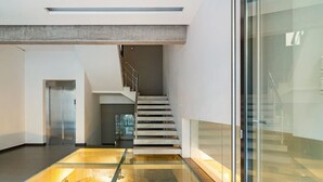 A modern interior with a glass floor leading to a staircase. - Modern Oasis Build on Acropolis Ruins Free Parking (Athina)