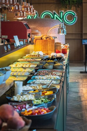 A buffet with various food items and a coffee machine.