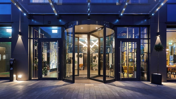 A modern hotel entrance with a revolving door, glass doors, and a well-lit interior. - Stay inn Hotel Warszawa  (Warsaw)