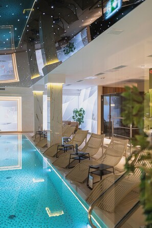 Una piscina cubierta, tumbonas