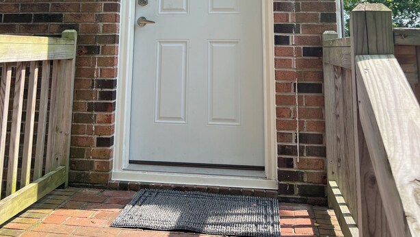 A white door with the numbers 3 and 2, a small window above it, and a wooden gate to the left.