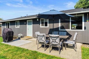 A house with a patio, outdoor furniture, a grill, and a large umbrella. - This house is a 3 bedroom(s), 1 bathrooms, located in Enumclaw, WA. (Enumclaw)