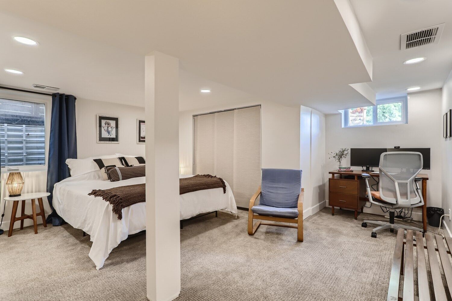 Una habitación de hotel moderna con una cama, un escritorio, una silla y una ventana.