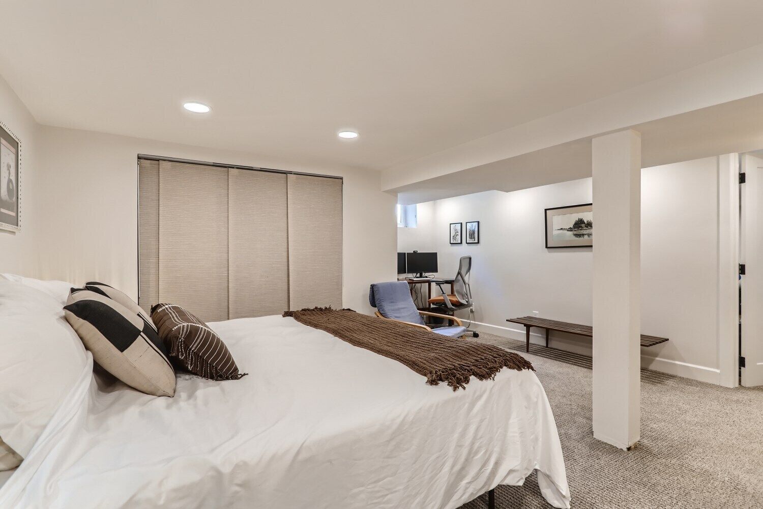 Une chambre d’hôtel moderne, dotée d’un grand lit, d’un bureau et d’un ordinateur.