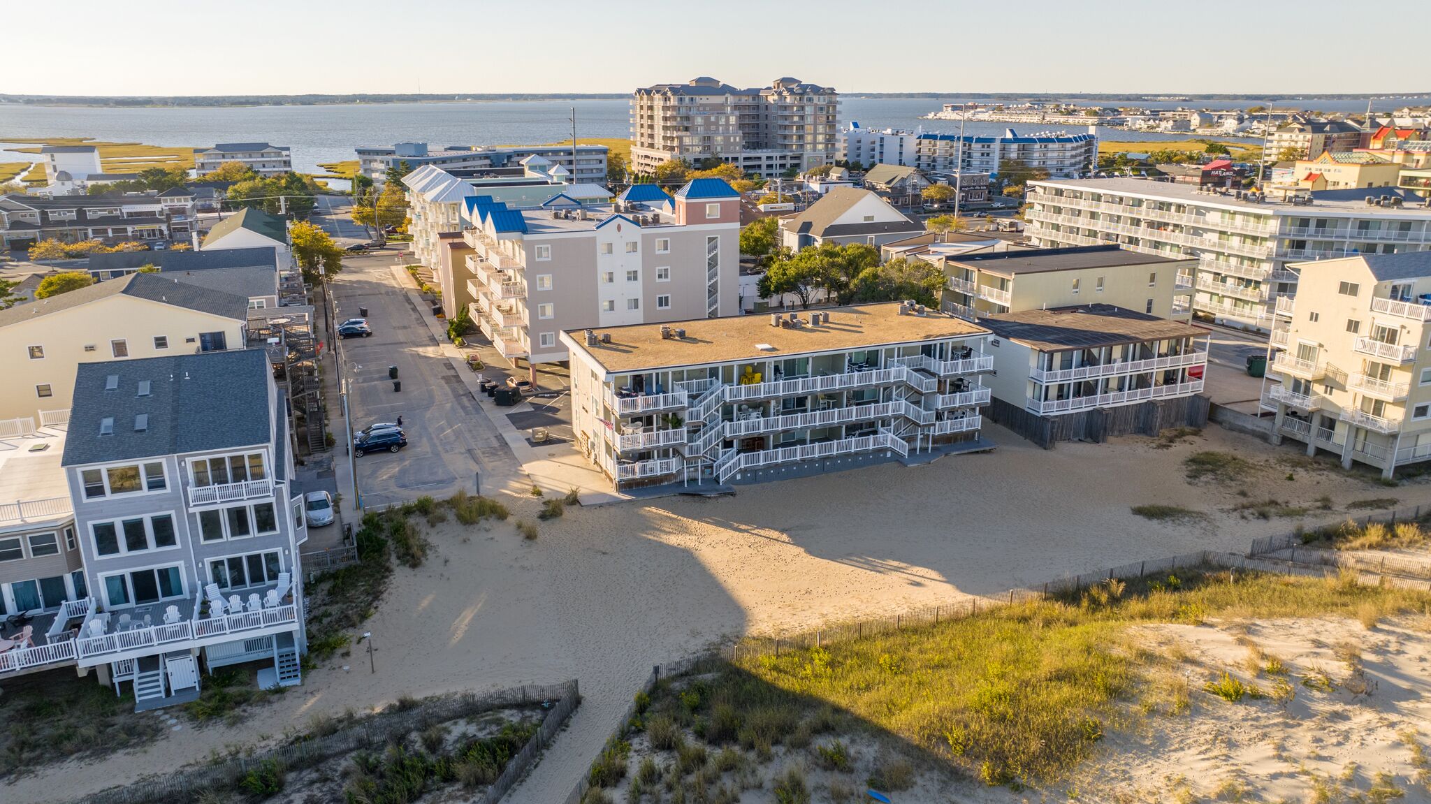 A coastal hotel with multiple floors, balconies, and a beach view.