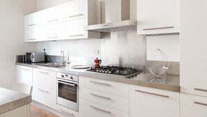 A modern kitchen with white cabinets, stainless steel appliances, and a gas stove. - Artsy and Elegant Apartment near Pantheon (Roma)
