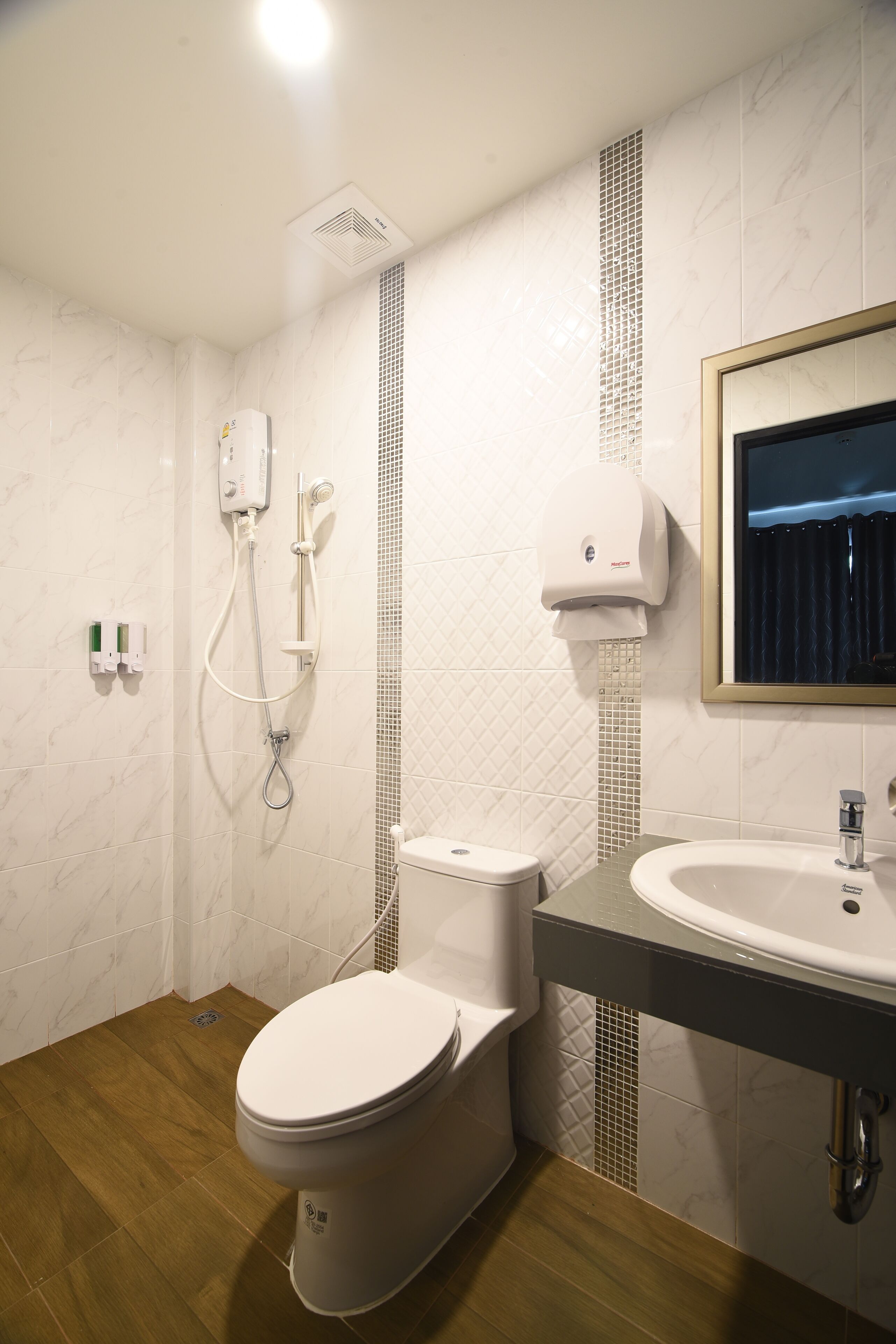 A modern bathroom with a toilet, shower, and sink.