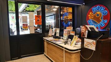 A counter with informational posters, a neon sign, and a window with a 'PUSH' sign.