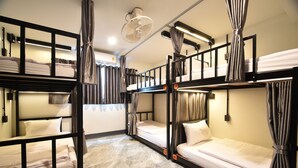 A dormitory-style room with bunk beds, a ceiling fan, and curtains. - KOKO Hostel- Adults Only  (Krabi)