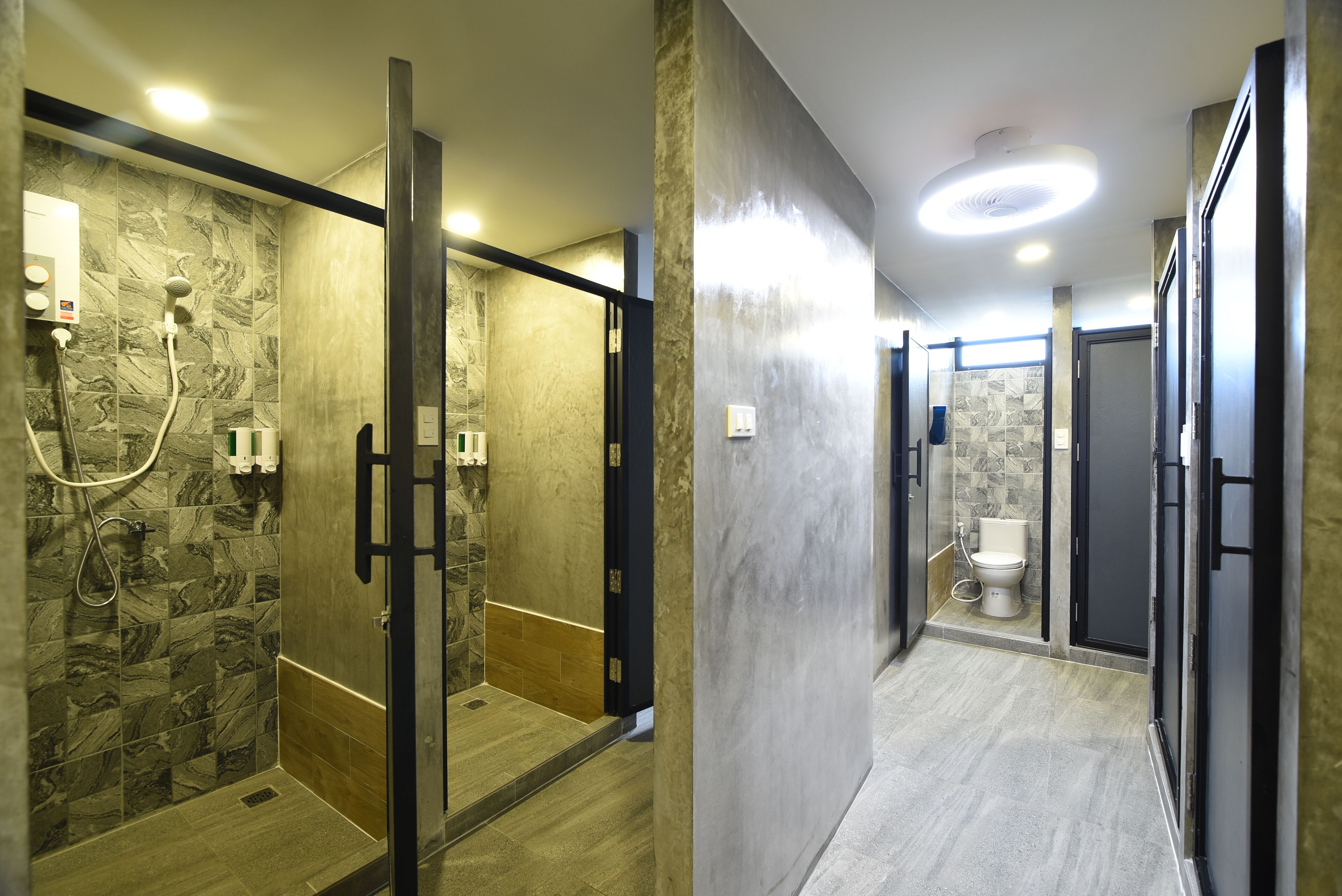 A modern bathroom with a shower, toilet, and a walk-in shower stall.