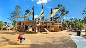 Un parque infantil con tema de piratas, que incluye toboganes y estructuras para escalar.