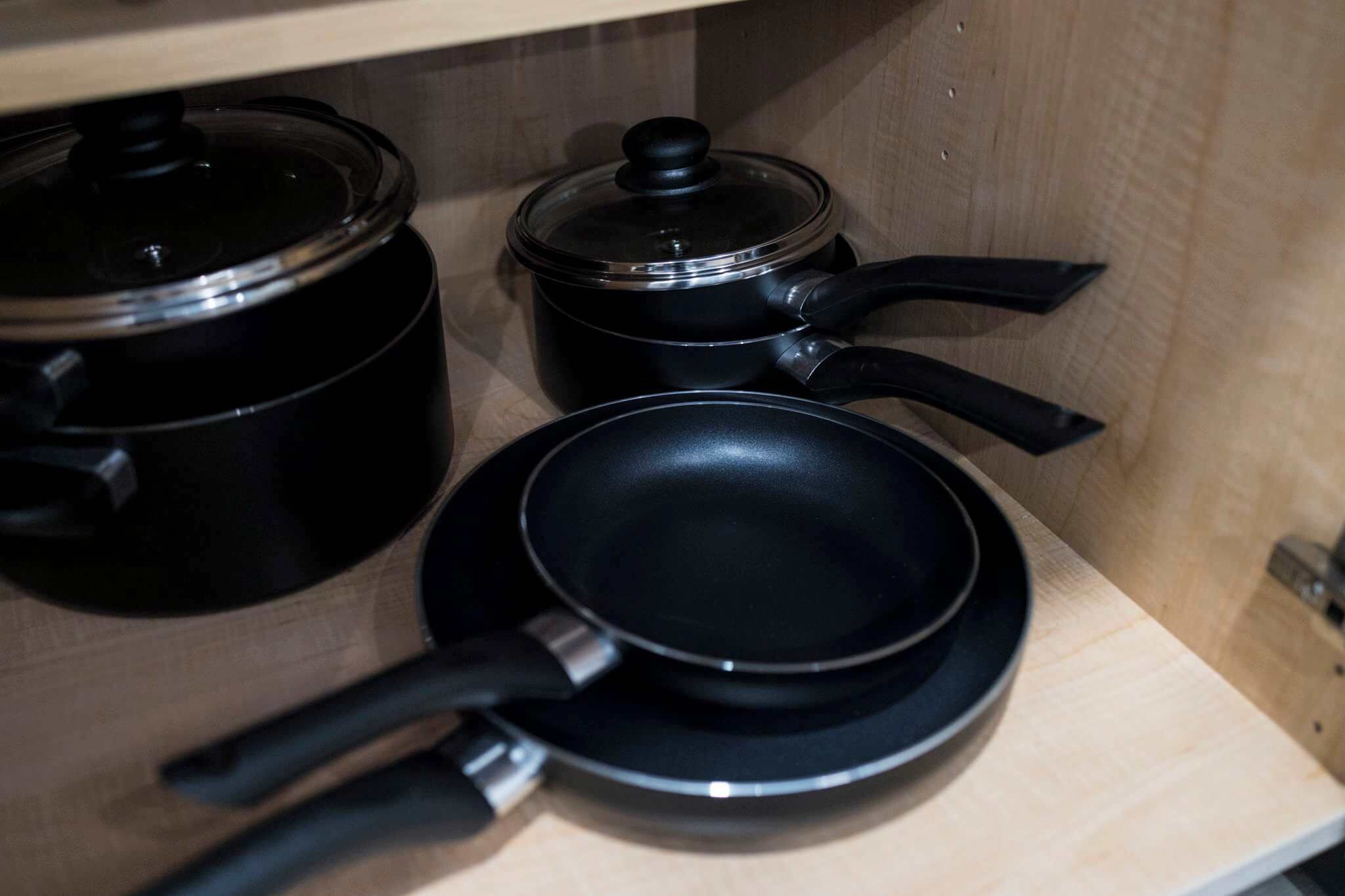 A kitchen with a stove, a frying pan, and a pot.