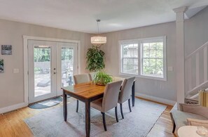 Enjoy meals in this dining area with a view, featuring a table for four and a potted plant.