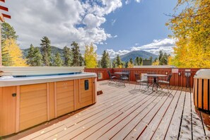 A wooden deck with a hot tub, outdoor seating, and a view of mountains. - Private Balconies and Huge Windows for Gorgeous Mountain Views! (Keystone)