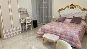 A bedroom with a bed, a desk, a chair, a wardrobe, and a small table. - Nicole House (Reggio Calabria)