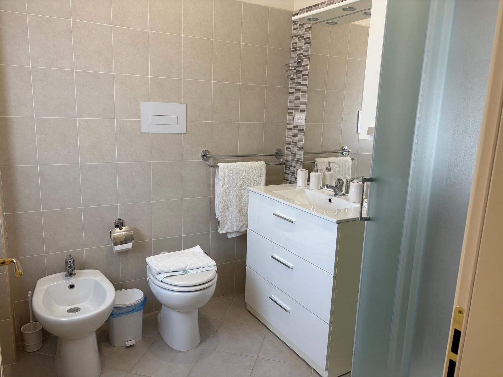 Een moderne badkamer met een wastafel, toilet en badkamermeubel.
