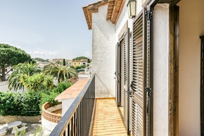 A balcony with a view of a cityscape, a wooden floor, and a metal railing. - Holiday Home "Casa Saguer" with Terrace, Garden & Pool (L'Escala)