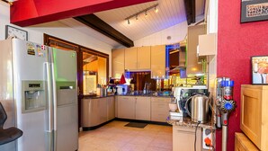Une cuisine moderne dotée d’appareils électroménagers en acier inoxydable, de meubles en bois et d’un mur d’accent rouge.