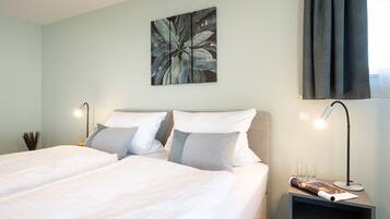 Una habitación de hotel con una cama, dos mesitas de noche y una obra de arte colgada en la pared.
