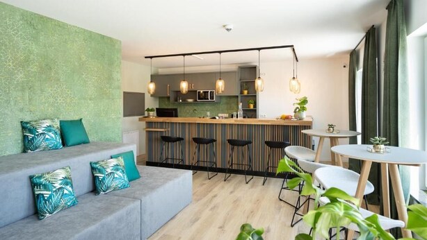 Un interior moderno con zona de cocina, barra y disposición de asientos.