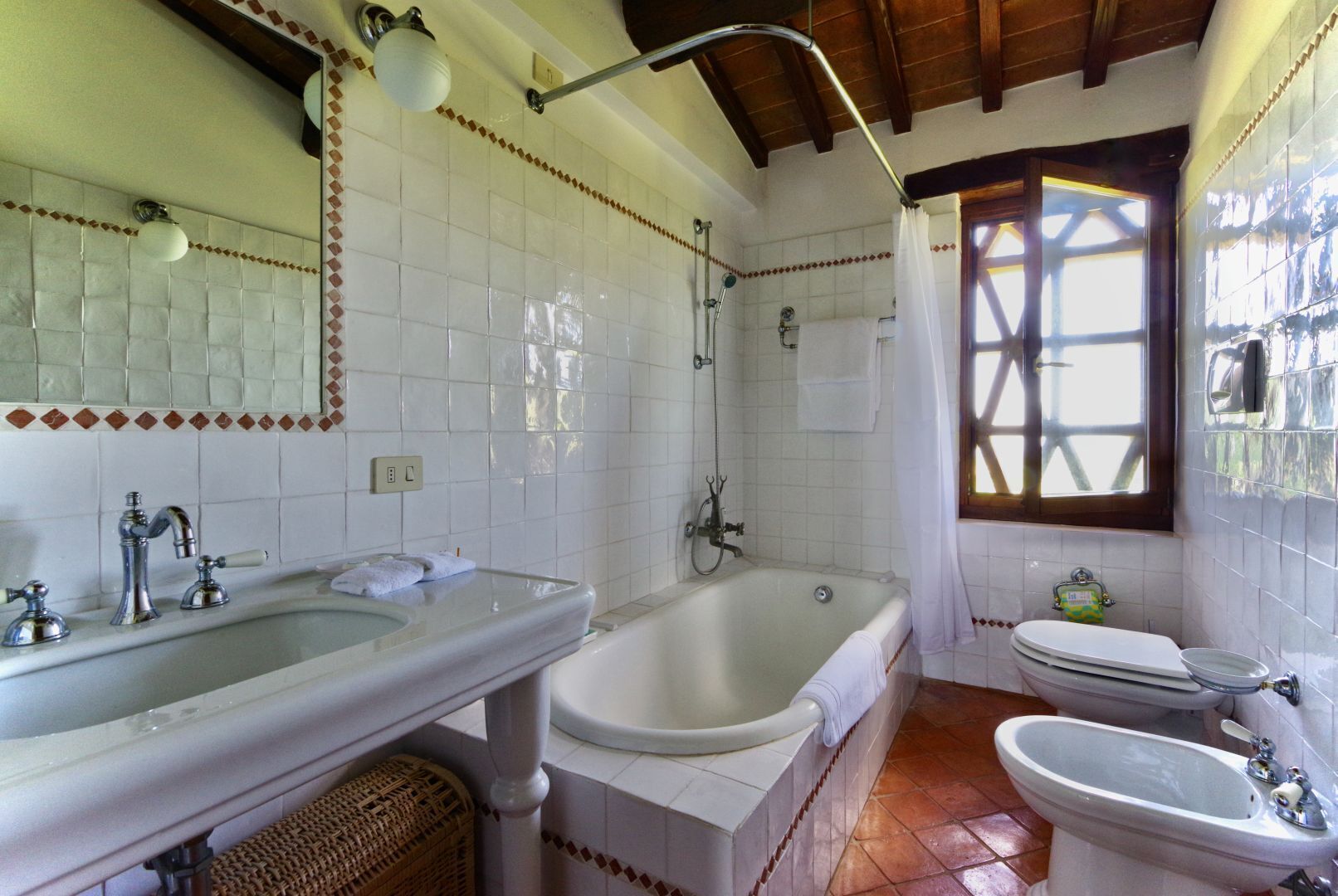 A bathroom with a large bathtub, a separate shower area, a toilet, and a bidet.