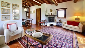 Un ampli saló amb una llar de foc, zona de menjador i una zona de seients acollidora amb un rug elegant.