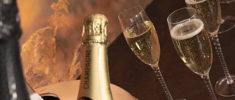 A bottle of champagne and three glasses filled with champagne.