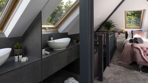 A modern bathroom with a large white sink, dark tiles, and a skylight. - Stay at-FL (Crawley)