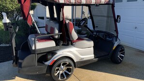 A golf cart parked in front of a house with a garage. - Beautiful 2/2 Villa w/4 Seater Gas Golf Cart, BBQ Grill, and WiFi!! (The Villages)
