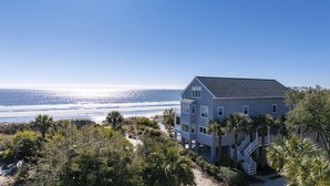 A two-story house with a balcony overlooking the beach, surrounded by dense vegetation. - 20 Ibis -Oceanfront, 7 Bedroom home w/ private pool.  Sleeps 19 (Hilton Head Island)