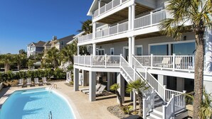 A multi-story hotel with a pool, balconies, and palm trees. - 20 Ibis -Oceanfront, 7 Bedroom home w/ private pool.  Sleeps 19 (Hilton Head Island)