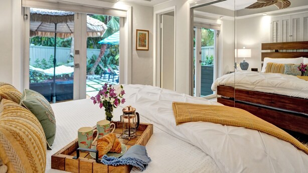 A hotel room with a large bed, a breakfast tray, a coffee maker, and a view of the outdoor area. - By Pier- Heated Pool- 5 Stars! Marbella (Fort Lauderdale)