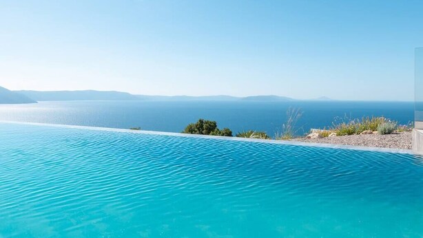 A clear view of a swimming pool with a distant body of water and a clear sky. - Villa Aristea with sea view, jacuzzi&infinity pool (Ripenda Kosi)